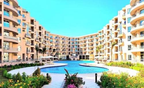 a large apartment building with a large swimming pool at Hotel Room in Princess Resort With Beach Acces & Free Wi-fi I Near Air port in Hurghada