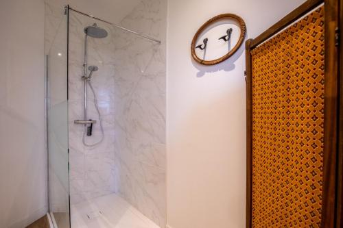 a bathroom with a shower and a clock on the wall at Domaine les Hilliers in Bains-sur-Oust