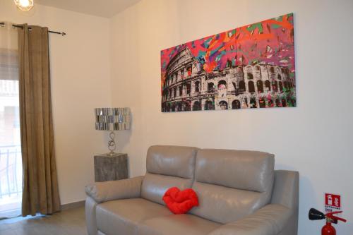 a living room with a couch and a painting on the wall at Casa Rolland in Acilia