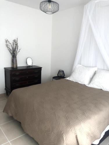 a bedroom with a bed and a dresser at Apt H - Beach Village in Olhos de Água