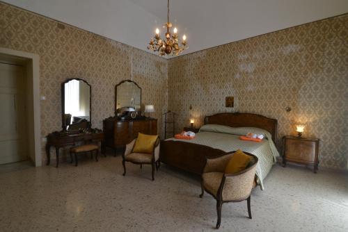 a bedroom with a bed and a table and chairs at Basilicata Host to Host-Casa Eleonora in Pisticci