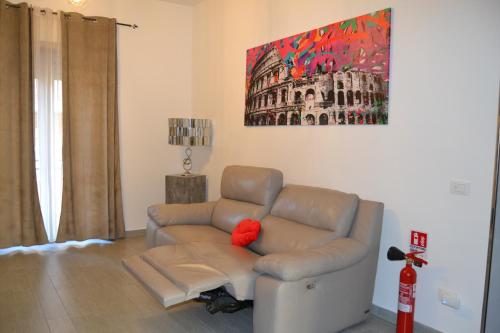 a living room with a couch with a red pillow at Casa Rolland in Acilia