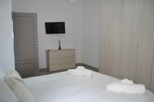 a bedroom with a white bed with two towels at Casa Rolland in Acilia