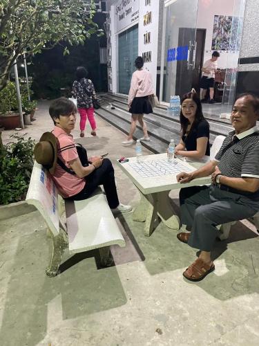 a group of people sitting around a table playing a game at Nhà Nghĩ Hồng Hải in Ap Vi Binh