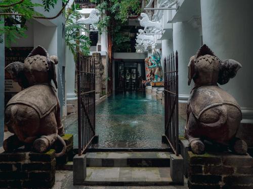 a corridor in a building with two statues of elephants at House of Tugu, Old Town Jakarta in Jakarta