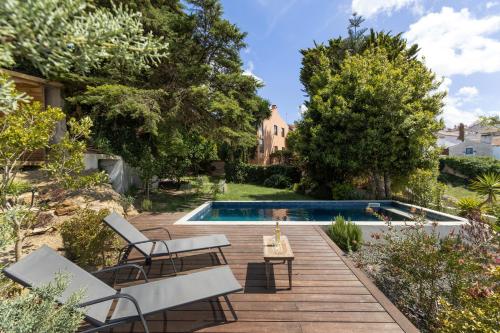 a backyard with a swimming pool and a wooden deck at Sobral Serenity Villa in Amoreira