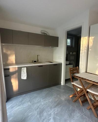 a kitchen with a counter and a table and chairs at Szigligeti Strand Apartman in Szigliget