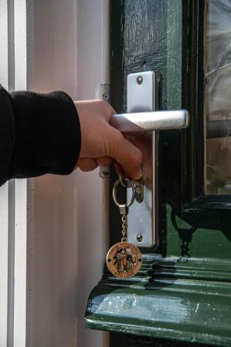 a person holding a key to a door at B&B Saense huisje in Assendelft