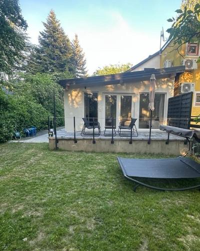 a house with a patio with a table and a boat at Szigligeti Strand Apartman in Szigliget