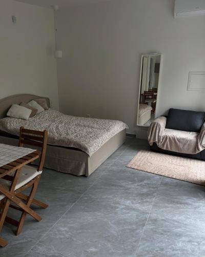 a bedroom with two beds and a table and a chair at Szigligeti Strand Apartman in Szigliget