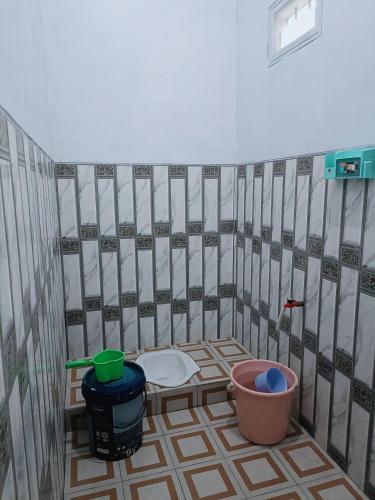 a bathroom with a tiled floor with a toilet at Alza in Tamperan