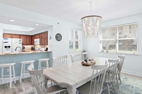 a kitchen and dining room with a wooden table and chairs at Ariel Dunes II 101 in Destin