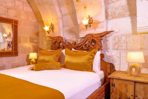 a bedroom with a bed and a table with lamps at Onur Cave Cappadocia in Goreme
