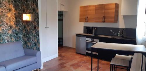 - une cuisine avec un canapé et une table dans une chambre dans l'établissement Studio calme en centre historique, à Aix-en-Provence