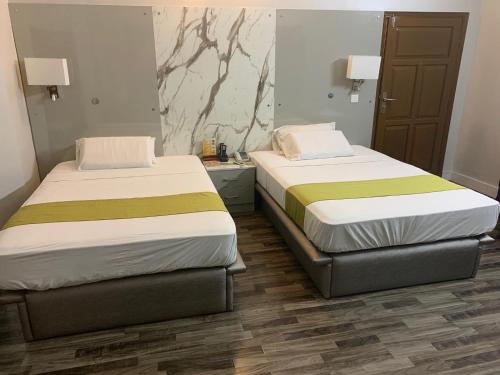 two beds in a room with two beds sidx sidx sidx at Star Guest House in Karachi