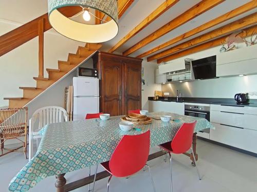 une salle à manger avec une table et des chaises rouges dans l'établissement Studio duplex 4 pers avec balcon, parking et accès direct plage - Noirmoutier-en-l'Île - FR-1-224B-527, à Noirmoutier-en-l'lle