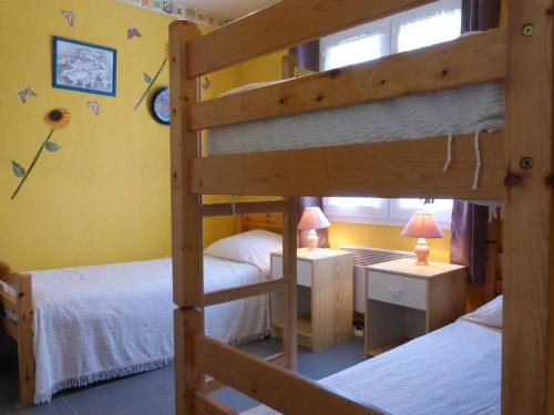 deux lits superposés dans une chambre aux murs jaunes dans l'établissement Maison 3 pièces, 5 couchages à Landevieille, terrasse, Wi-Fi - FR-1-224A-8, à Landevieille