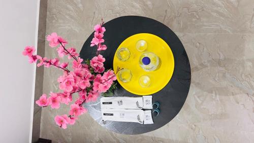 a table with a yellow plate and flowers on it at THE ELEGANT VILLA WITH KITCHEN, Opp to Mangrove Boating - JR Groups in Puducherry