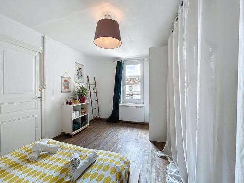 une petite pièce avec un lit et une fenêtre dans l'établissement Le Bohja - Charming apartment near Les Halles, à Narbonne