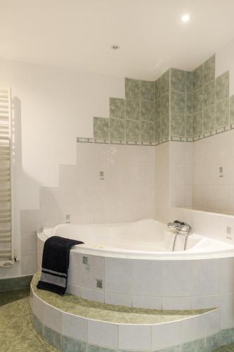 - une salle de bains blanche pourvue d'une baignoire dans l'établissement Colmar Apartment, à Colmar