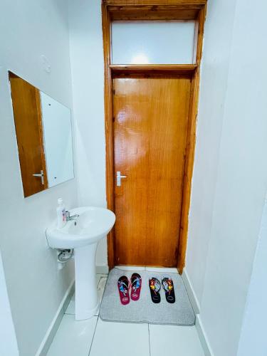 a bathroom with a sink and a pair of shoes at Comfort Home 2Bedroom Buxton point Mombasa in Mombasa