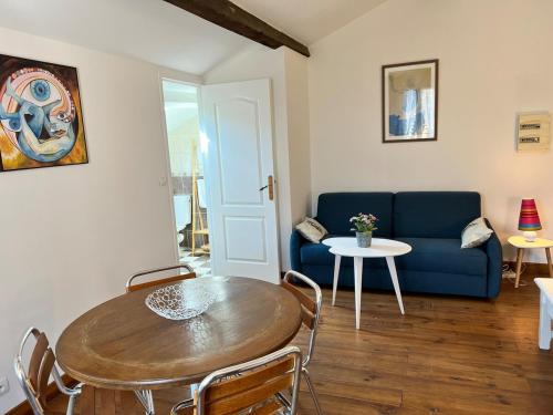 un salon avec une table et un canapé bleu dans l'établissement Nid au pied du Mont Caroux, à Le Poujol-sur-Orb