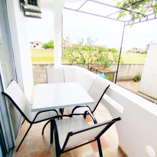 a white table and two chairs on a balcony at Apartments Hija in Donji Štoj