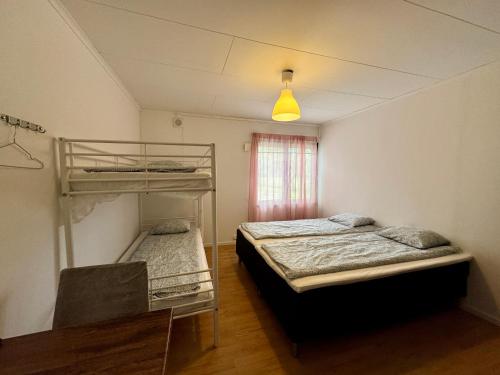 a bedroom with two bunk beds and a table at Hässlebogården Turist & Konferens in Mariannelund