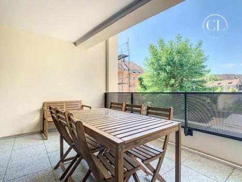 une table et des chaises en bois sur un balcon dans l'établissement Appartement de charme neuf, à Colmar