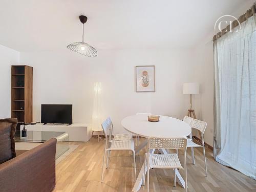 un salon avec une table et des chaises blanches dans l'établissement Appartement de charme neuf, à Colmar