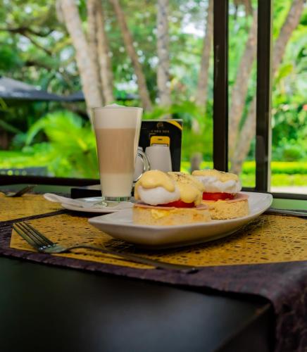 a table with a plate of food and a glass of milk at Casa Mia Lodge & Restaurant in Blantyre