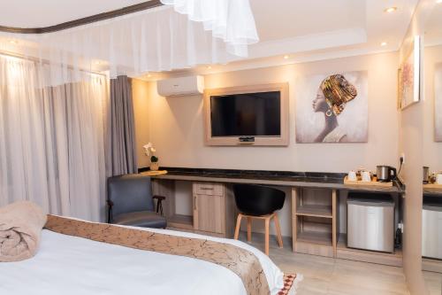 a hotel room with a bed and a desk at Casa Mia Lodge & Restaurant in Blantyre