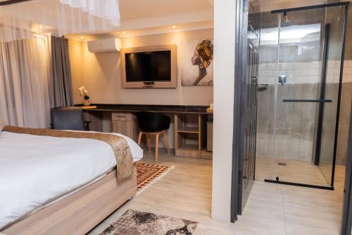 a bedroom with a bed and a desk and a shower at Casa Mia Lodge & Restaurant in Blantyre