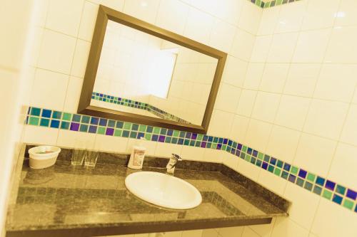 a bathroom with a sink and a mirror at Casa Mia Lodge & Restaurant in Blantyre