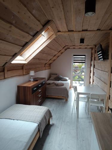a bedroom with two beds and a table and a dining room at Krutyńska Sielanka in Piecki