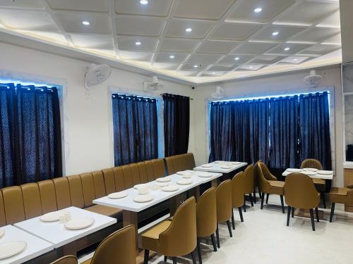 a dining room with tables and chairs and blue curtains at hotel deep palace in Varanasi