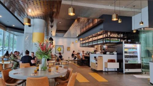 a restaurant with people sitting at tables and a bar at Brand new 1B apartment in Woden near Hospital Westfield and pool gym in Phillip