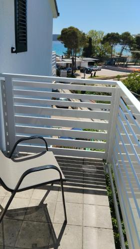 a white bench sitting on the side of a fence at More in Vodice