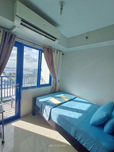 a bedroom with a bed and a large window at Sea Residences Mall of Asia Viann in Manila
