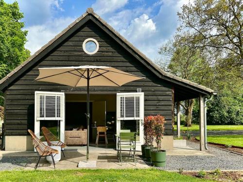 a small house with an umbrella and chairs at Wilde Gist Guesthouse in Sint Agatha