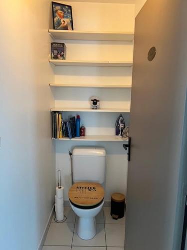 La salle de bains est pourvue de toilettes et d'un siège en bois. dans l'établissement Bel appartement proche du marché, à La Rochelle