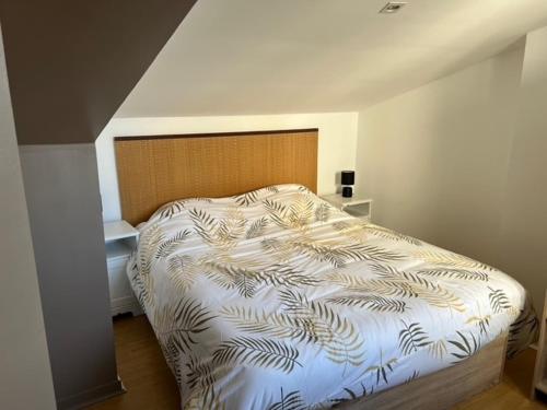 une chambre avec un lit avec une couette blanche dans l'établissement Bel appartement proche du marché, à La Rochelle