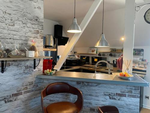 une cuisine avec un comptoir, un évier et des chaises dans l'établissement Bel appartement proche du marché, à La Rochelle