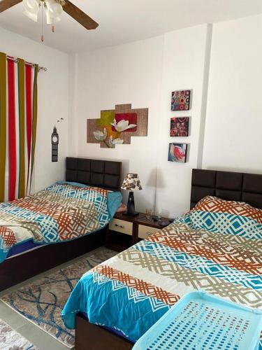 two beds sitting next to each other in a bedroom at Amwaj ground apartment in El Alamein