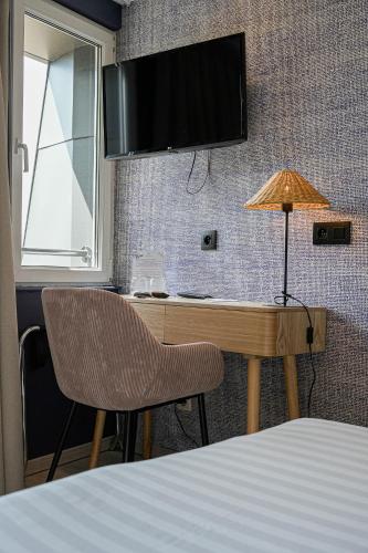 a bedroom with a desk with a television and a chair at Hôtel Panorama - Vue exceptionnelle sur la Semois in Bouillon