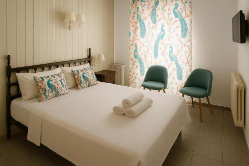 a bedroom with a large white bed with two chairs at Mallorca Boutique Hotel in Malgrat de Mar