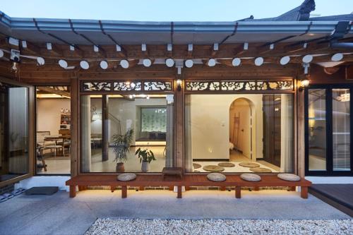 Una casa con una gran pared de cristal con patio. en Suncheon 20 days hanok private stay, en Suncheon