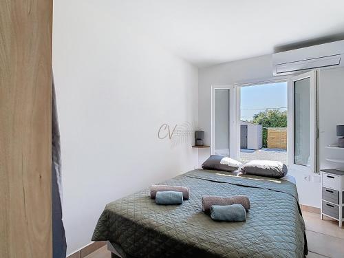 deux lits dans une chambre blanche avec une fenêtre dans l'établissement Maison La Corsica - Vias Village, à Vias