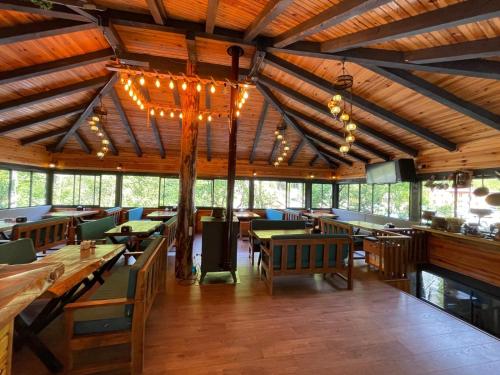 a restaurant with wooden tables and chairs and lights at Lazmaris Suit in Çamlıhemşin