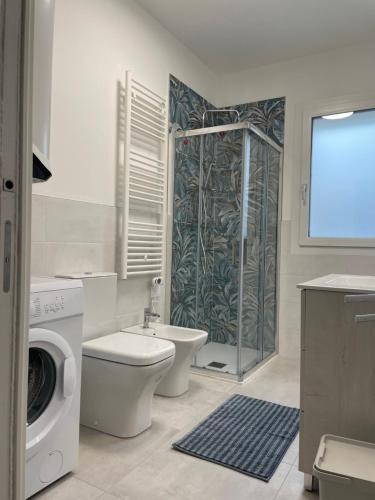 a bathroom with a toilet and a shower and a washing machine at Marina Garden in Cattolica
